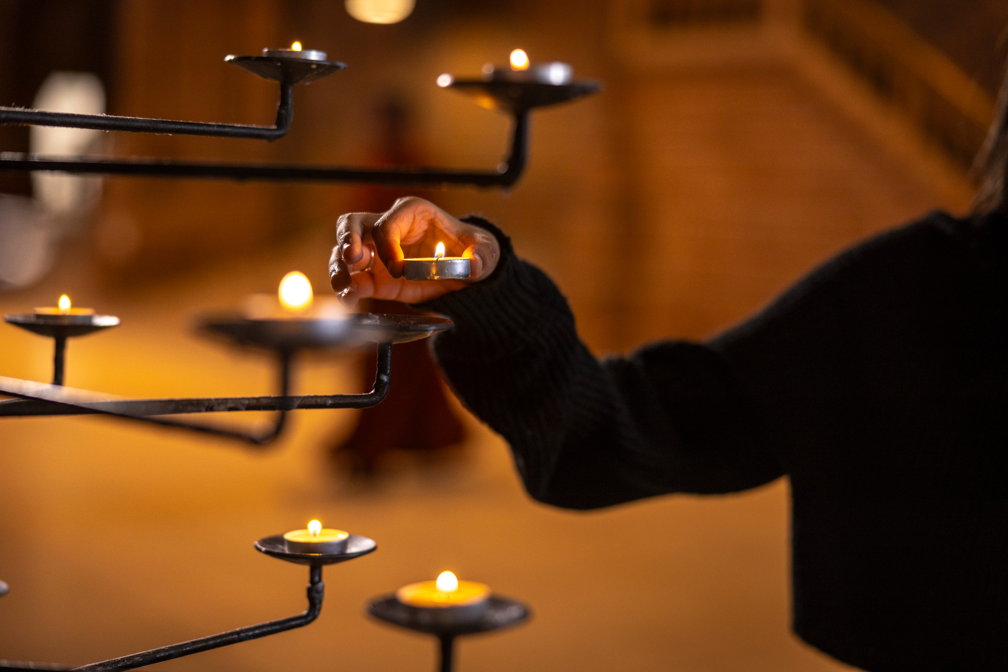 Peoples-Path_Selects162_Header Someone lighting a candle and placing on the candle pricket at Liverpool cathedral