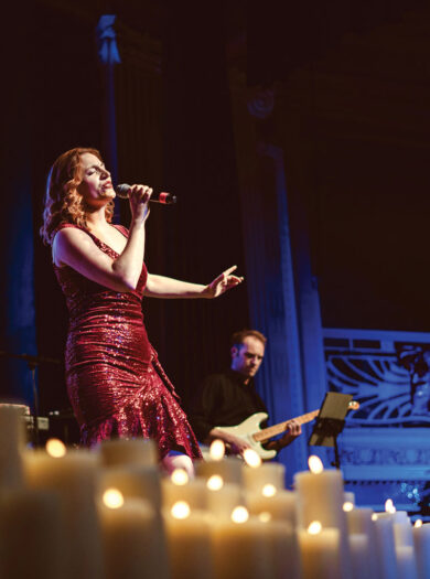 Candlelight concert image of lady singing and Cathedral lit by Candles